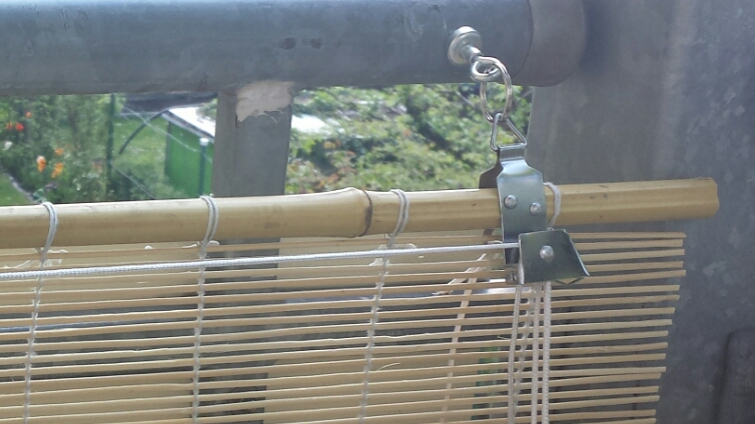 Magnetic fastening of a blind on a balcony